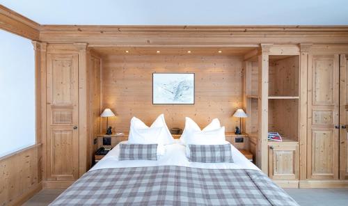 a bedroom with a bed with white sheets and pillows at Chalet RoyAlp Hôtel & Spa in Villars-sur-Ollon