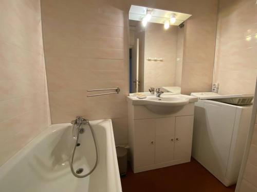 une salle de bain avec une baignoire et un lavabo et une baignoire dans l'établissement Appartement T3 climatisé avec 6 couchages, terrasse et parking à 300m des commerces - FR-1-81-490, au Barcarès