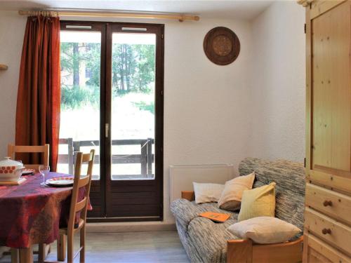 un salon avec un canapé et une table dans l'établissement Appartement T2 calme avec balcon sud, parking gratuit, navette proche - 4 couchages à Risoul 1850 - FR-1-330-520, à Risoul