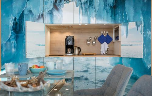 a kitchen with a blue wall with a table and chairs at Feriendorf Waidlerland in Mauth