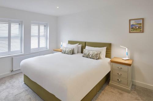 a bedroom with a large white bed and two windows at Host & Stay - Even Keel in Whitby