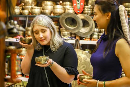 two women standing in a store looking at a bowl at Dahlia Boutique Hotel in Pokhara