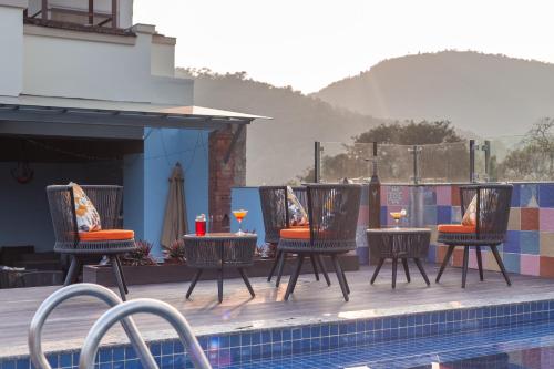 a group of chairs and tables next to a swimming pool at Dahlia Boutique Hotel in Pokhara