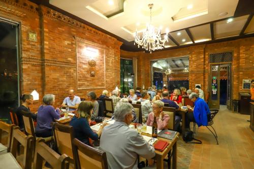 a group of people sitting at tables in a restaurant at Dahlia Boutique Hotel in Pokhara