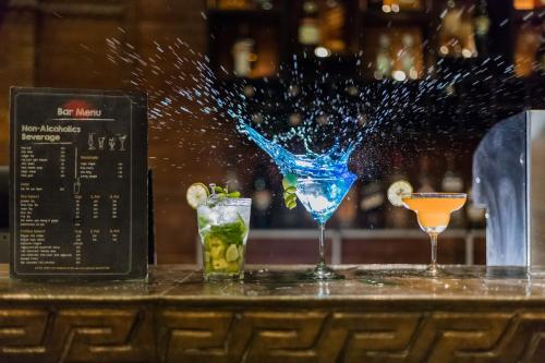 two cocktails sitting on top of a bar at Dahlia Boutique Hotel in Pokhara