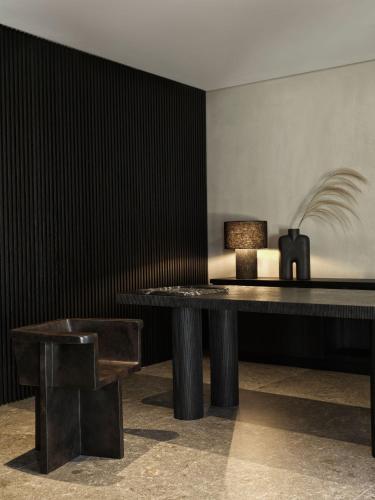 a table and a chair in a room at Noima Boutique Hotel Mykonos in Agios Ioannis Mykonos