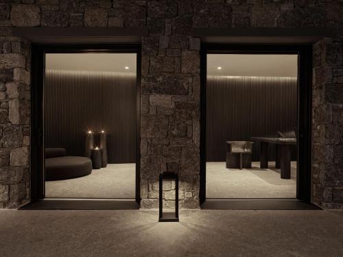 a room with two mirrors and a couch and a table at Noima Boutique Hotel Mykonos in Agios Ioannis Mykonos