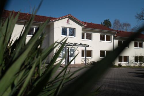 a white building with a red roof at Haus Hotel Inter in Buxtehude