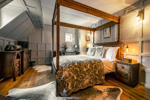 a bedroom with a canopy bed and wooden floors at White Rose Tower in Invergordon