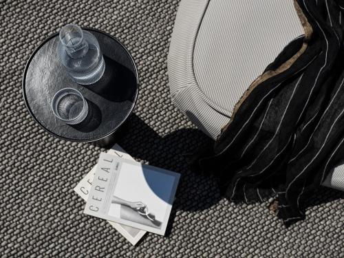 a bottle of water sitting next to a suitcase at Noima Boutique Hotel Mykonos in Agios Ioannis Mykonos