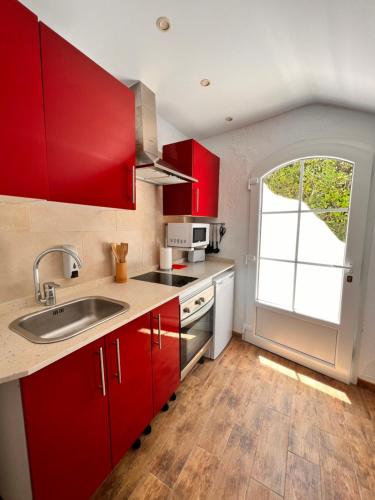 a kitchen with a sink, stove and refrigerator at Apartamentos El Bergantin Menorca Club in Fornells