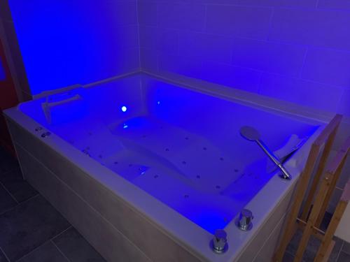 eine Badewanne mit blauem Licht im Bad in der Unterkunft Studio Cosy avec Jacuzzi Privatif et Terrasse in Hazebrouck