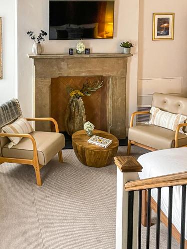 a living room with two chairs and a fireplace at Parador 44 in Cardiff