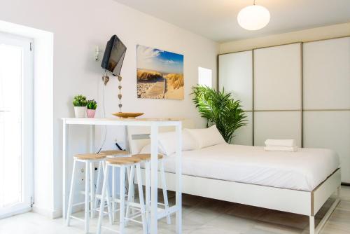 1 dormitorio con 1 cama y 1 mesa en Livingtarifa Apartamento Bianco, en Tarifa