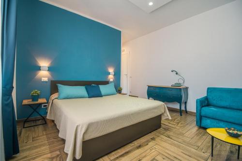 una camera con un letto e un divano blu di Spaghetti House a Napoli