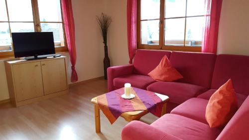 uma sala de estar com um sofá roxo e uma televisão em Bühlhof Todtnauberg Wohnung 3 em Todtnauberg