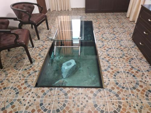a living room with a glass table on a tiled floor at Къщата с разкопките in Sozopol