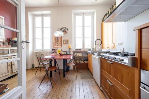 Il comprend une cuisine dotée de parquet et d'une table. dans l'établissement Sansas, à Bordeaux