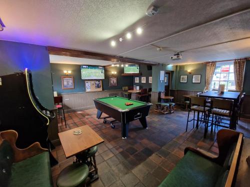a pub with a pool table in the middle of a room at The Foresters Arms in Tarporley