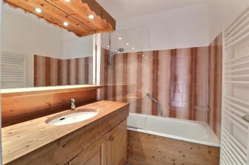 une salle de bain avec un lavabo et une baignoire dans l'établissement Residence Plein Soleil, à Méribel