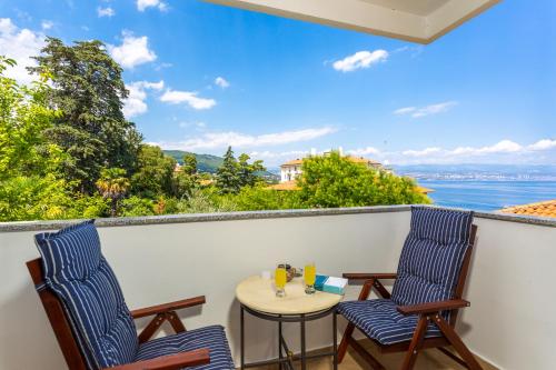 two chairs and a table on a balcony with a view of the water at Apartment Vita in Lovran