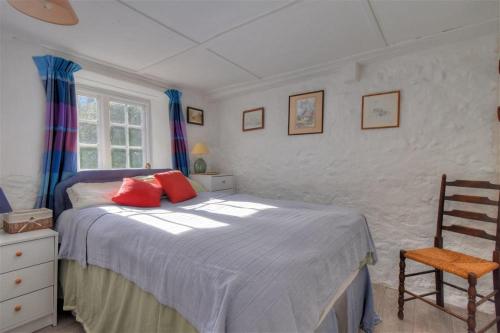 a bedroom with a bed with red pillows on it at St Gabriels Cottage in Charmouth