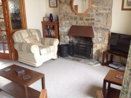 a living room with a couch and a fireplace at 3 bedroom Grade II Listed Holiday Cottage in Saint Erth