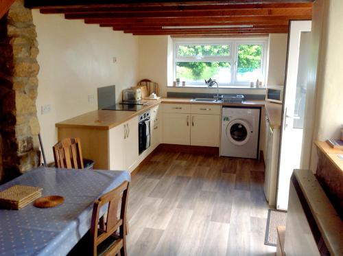 a kitchen with a sink and a washing machine at 3 bedroom Grade II Listed Holiday Cottage in Saint Erth