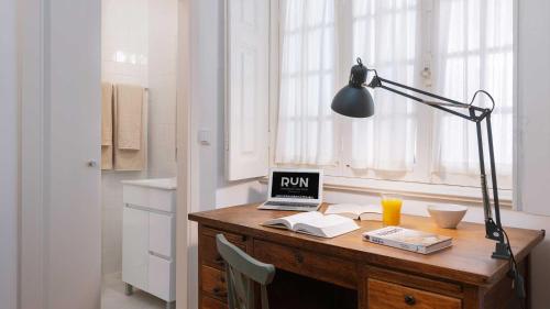 a desk with a laptop and a lamp on it at RUN Aveiro in Aveiro