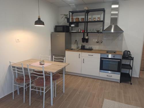 een keuken met een tafel en een fornuis top oven bij Apartman Vranac in Vela Luka