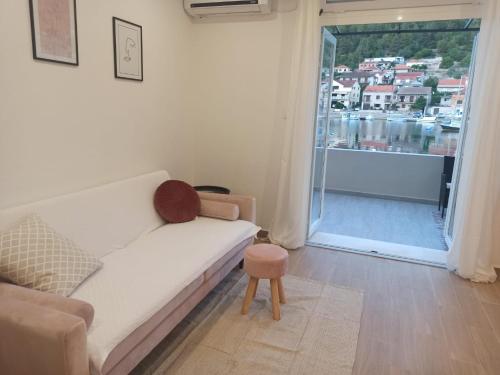 a living room with a white couch and a balcony at Apartman Vranac in Vela Luka