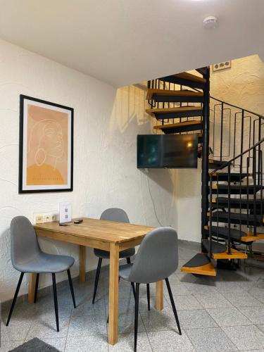 a dining room with a table and chairs and a staircase at Residenz am Kurpark - Ferienwohnungen in zentraler Lage I Privatparkplatz in Bad Rothenfelde