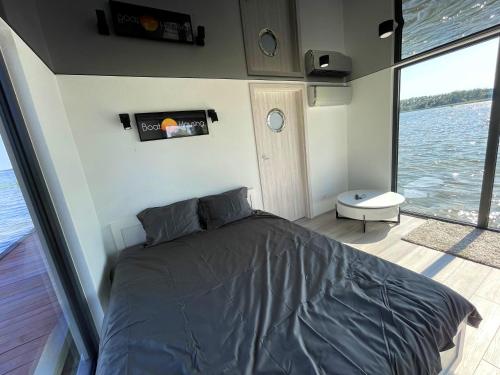 un dormitorio en un barco con una cama en él en Boathousing - apartament na wodzie, dom pływający, łódź, luksusowy apartament, en Myślibórz