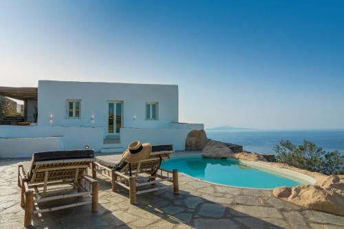 uma villa com piscina e 2 cadeiras em Makarias Traditional Luxury Villas em Áno Meriá