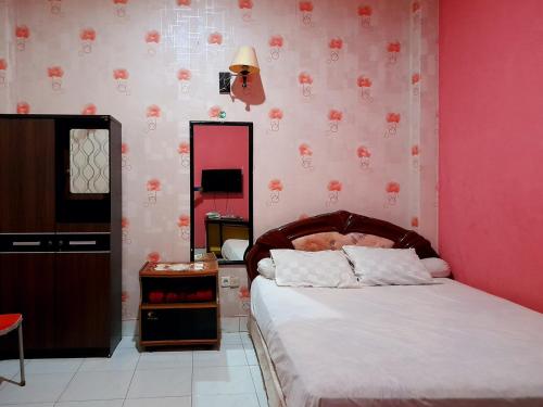 En eller flere senge i et værelse på Hotel Rosichan Bau Bau Mitra RedDoorz
