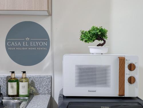 a white microwave with a plant on top of it at White Nordic Fully-Furnished Studio at INSPIRIA in Davao City