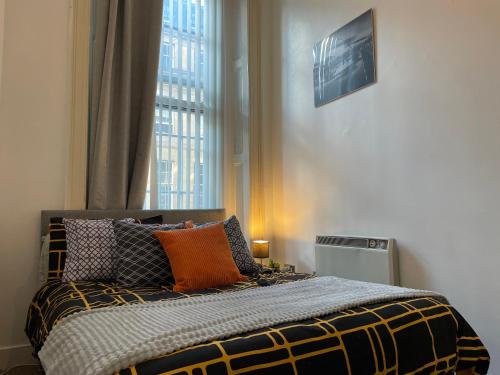 ニューカッスル・アポン・タインにあるEarl Grey flat by HNFC Stays - Finest tea & Coffeeのベッドルーム1室(オレンジ色の枕付きのベッド1台付)