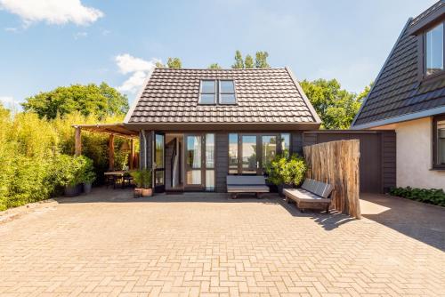 a home with a patio and a house at Berger Lodge in Alkmaar