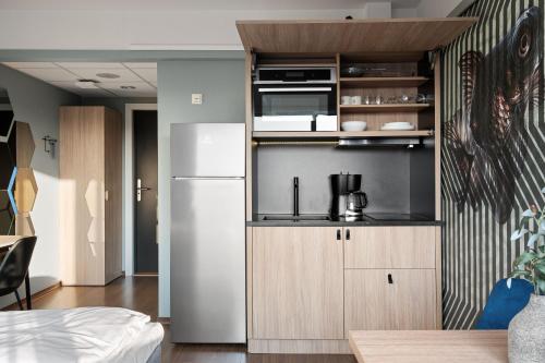 a kitchen with a refrigerator and a microwave at Bjørvika Apartments - Sirkus Renaa in Stavanger