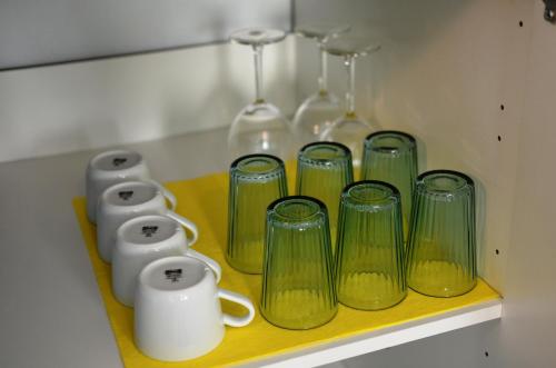 a shelf with four green glass vases on it at TIKE, TAK - Central Residence in Niš