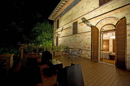 a patio with chairs and a table and a building at Villa Raffaello Park Hotel in Assisi