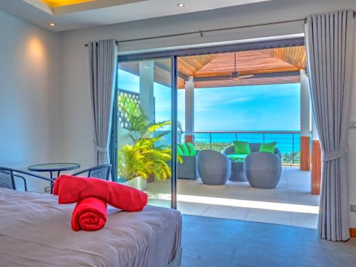 a bedroom with a bed and a view of the ocean at Villa AUREA Sea View in Koh Samui