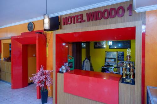 a hotel whoopoo store with a red counter and flowers at Hotel Widodo 1 Parangtritis RedPartner in Girijati