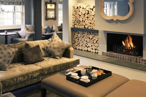 a living room with a couch and a fireplace at Sunday Box Hill Burford Bridge Hotel in Dorking