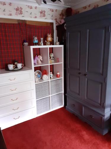 1 dormitorio con armario blanco y cómoda blanca en Single bed in large room, Sofa, netflix, garden view, patio door & seating, en Poole