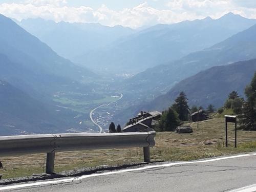 a road with a view of a valley with mountains at The Green Owl in Antey-Saint-André