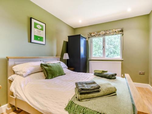 a bedroom with a large bed with green pillows on it at Peep o' Day in York