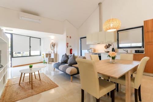 a dining room and living room with a table and a couch at Casa do Casal - Country House with Swimming Pool in Viana do Castelo