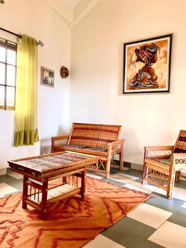 a living room with two benches and a table at Porto-Novo logement lumineux et calme in Porto-Novo