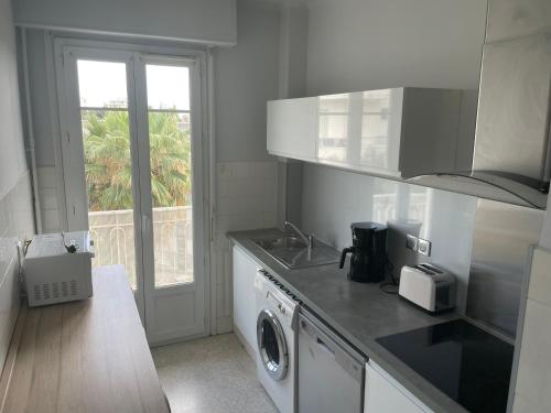 Il comprend une cuisine équipée d'un lave-linge, d'un évier et d'un lave-vaisselle. dans l'établissement Appartement spacieux au calme à Nice, à Nice